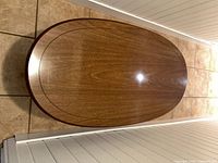 Top view of oval wooden coffee table showing wood grain and inlay