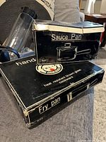 Boxes labelled Sauce Pan and Fry Pan showing product information