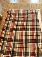 Plaid blanket spread on floor