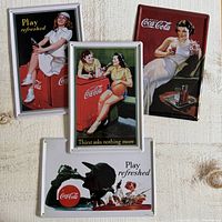 All four Coca-Cola tin signs front view