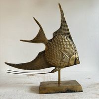 Full view of brass angelfish statue on stand