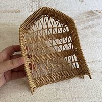 Front view of miniature wicker arch shelf showing three tiers and lattice back