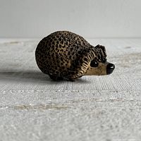Left side view of textured brown pottery hedgehog