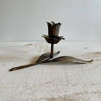 Angled view showing full brass flower ashtray base with leaf supports