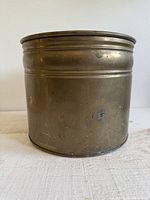 Front view of brass pot showing cylindrical form and patina