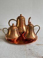 Front view of full copper and brass service set on tray
