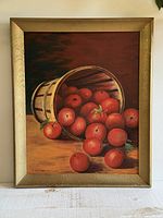 Full view of framed painting showing apples spilling from basket