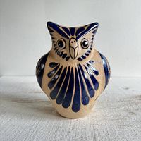 front view of tan and blue pottery owl figurine