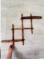 Full view of three-tier wooden shelf showing overall design and hanger