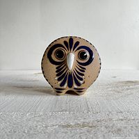 Front view of tan and blue stoneware owl figurine