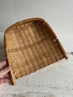 Angled view showing woven wicker scoop structure and bindings