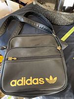 Full view of black Adidas messenger bag front with strap