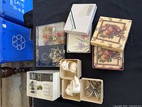 Overall view of boxed coasters, olive picks, napkin rings, wine charms