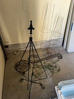 Group shot showing tripod plant hanger, multiple tomato cages, sunflower decor and other metal supports