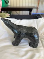 Left side profile of dark stone polar bear carving