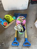 Group shot of rakes, gloves, pot, soccer ball, watering cans