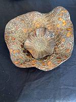 Large and small brown bronze fluted dishes stacked