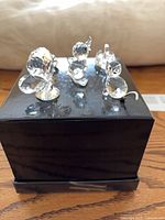 Group of five Swarovski crystal animal miniatures on black display stand