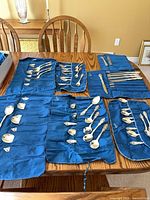 All blue roll bags opened showing sorted flatware pieces