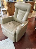 Front angled view of beige leather recliner showing upholstery and overall design