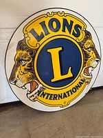 Front view of round Lions International metal sign showing graphics and condition