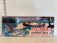 Front view of embossed metal sign with graphics and ruler for scale