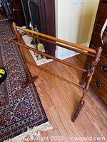 full view of stained pine towel rail stand showing three rails and overall structure