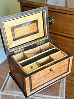 Open lid view showing banded inlay on interior lid and removable tray with compartments