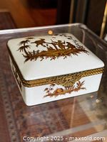 Square porcelain trinket box closed showing gold chinoiserie scene and lace band