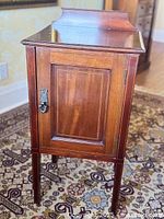 Full view of cabinet front showing overall design, inlay, door, legs, backsplash