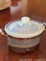 Dish with lid seated in silver-plated holder, perspective view