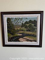 Framed George Thomson landscape oil painting on wall