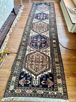 Full length view of hand-woven runner rug showing pattern and fringe
