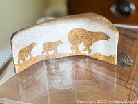 Front view of curved stone carving showing bear silhouettes