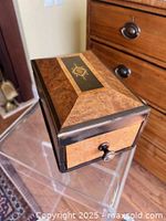 Front and top view of burl wood inlay box showing button on drawer front and star motif on lid