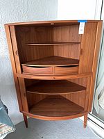 Full view of corner cabinet showing upper and lower sections, sliding doors, drawers, tapered legs