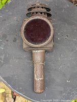 Front view showing red glass lens and metal body