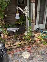 Full view of cast iron bridge floor lamp with shade and base visible