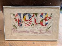 Full view of embroidered silk postcard in mount