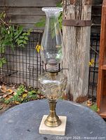 Full view of lamp showing marble base, brass stem, glass font and chimney
