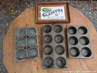 Overview of three tin trays and framed label