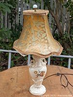 Full view of lamp with shade showing base, cord, finial