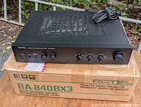 Amplifier resting on original box showing full front panel and attached power cord