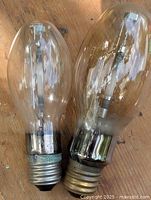 Front view of both large clear industrial bulbs side by side