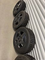 All four mounted winter tires lined up against wall