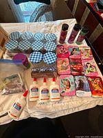 Overview of all items: puzzle tins, glue bottles, glass jars, glitter shakers, rhinestone bag