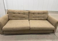Front view of 3-seater sofa showing upholstery, tufted back, track arms