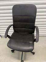 Front view of black office chair showing overall design, armrests, upholstery