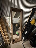 Full view of mirror leaning against wall