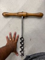 Large T-handle auger with hand for scale
